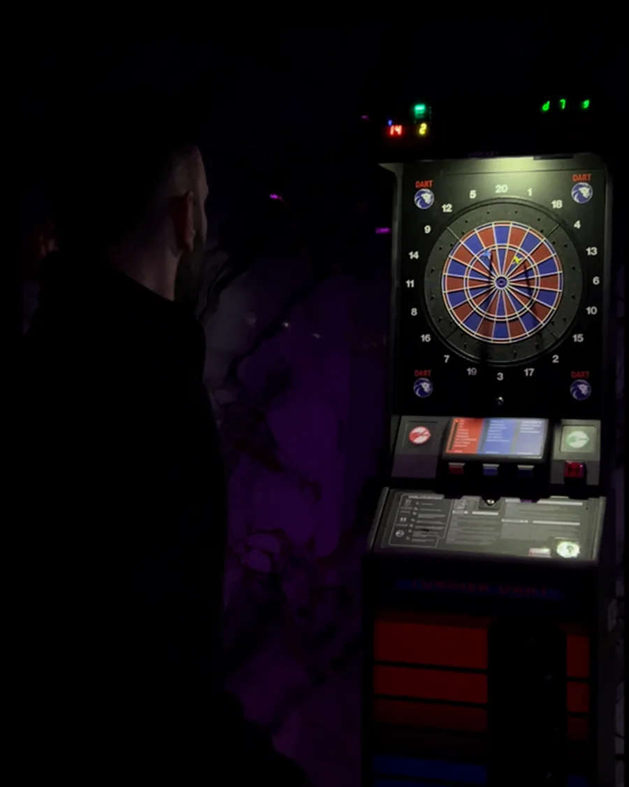 Spieler vor einer elektronischen Dartscheibe