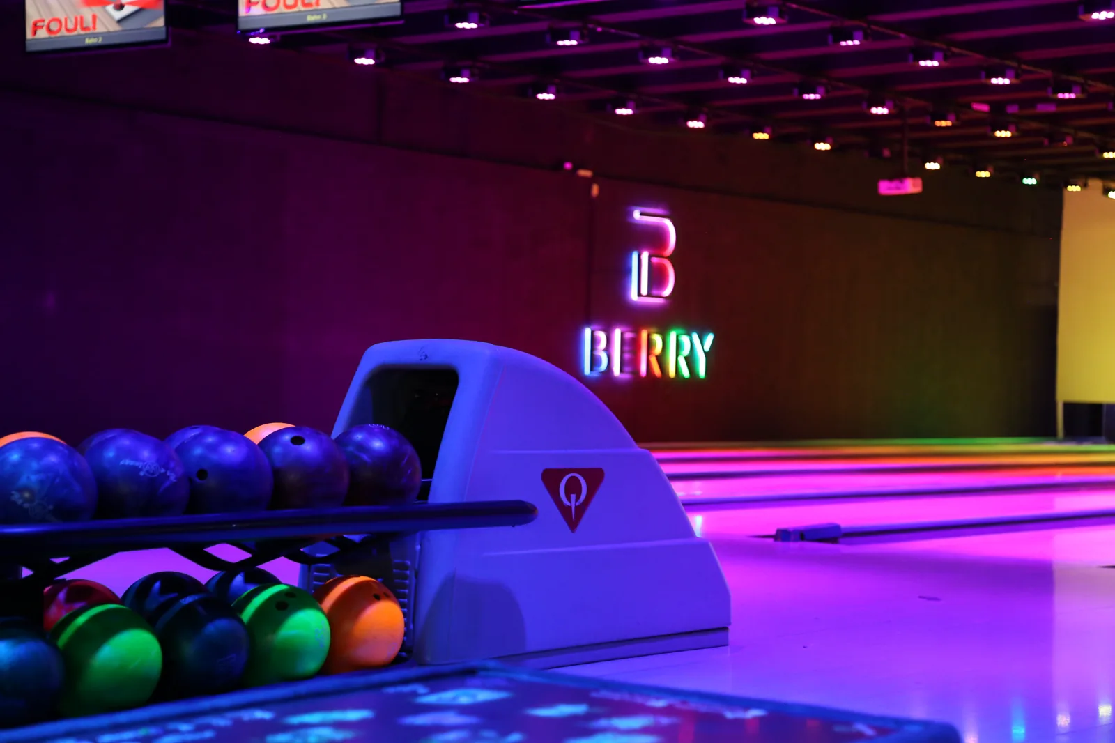 Bowlingkugeln vor den beleuchteten Bowlingbahnen im BERRY